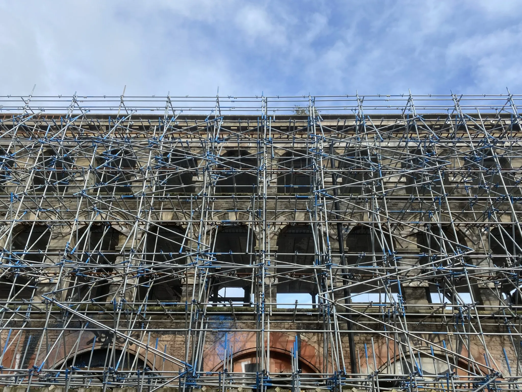 Immagine di contesto: facciata di un edificio interamente coperta da ponteggi durante un intervento di riqualificazione.