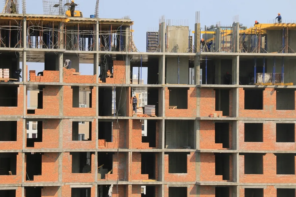 Immagine di contesto: edificio residenziale in costruzione con struttura in calcestruzzo e tamponamenti in laterizio.